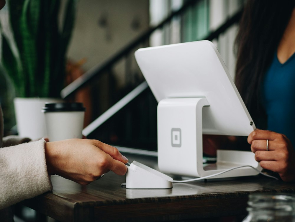 Cliente usando el móvil en el mostrador de un comercio local